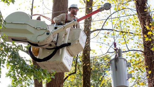 Georgia Power employee Arik Crawford replaces a transformer along West Paces Ferry Road on Friday.
