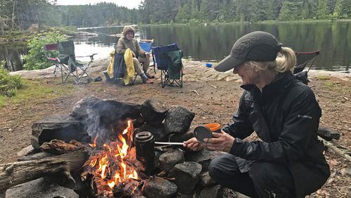 Patrice Aubrecht, foreground, prepares coffee at an island campsite in Quetico Provincial Park while Kathryn Erickson looks on. The two were part of a party of six women on the wilderness trip. (Handout/Minneapolis Star Tribune/TNS)