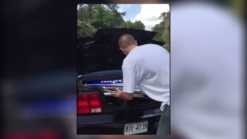 Roswell police arrested a man who appeared to put Jon Ossoff campaign signs in his trunk in a video circulated on social media. (Credit: Twitter)