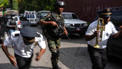 Police escort musicians arriving for the swearing-in ceremony of a transitional council tasked with selecting a new prime minister and cabinet at the Prime Minister's office in Port-au-Prince, Haiti, Thursday, April 25, 2024. (AP Photo/Ramon Espinosa)