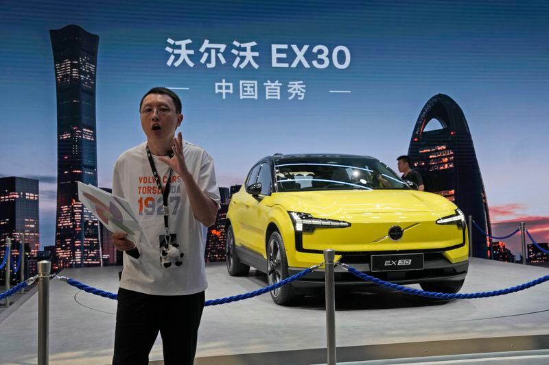 A live streamer chats about the Volvo EX30 fully electric small SUV unveiled during Auto China 2024 in Beijing, Thursday, April 25, 2024. China's vision of the future of the automobile — electrified and digitally connected — is on display at the ongoing Beijing auto show. (AP Photo/Ng Han Guan)
