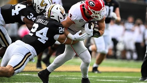 Georgia's Oscar Delp (4) picks up yardage in the second half as Vanderbilt's Nicholas Rinaldi (24) and Quantaves Gaskins (34) close in for the tackle at FirstBank Stadium on Saturday, Oct. 14, 2023, in Nashville, Tennessee. (Carly Mackler/Getty Images/TNS)