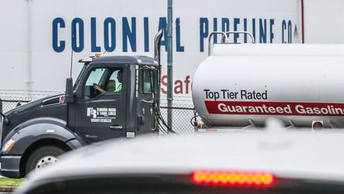 Gasoline tankers pass by the Colonial Pipeline storage tanks in Austell on Monday. A ransomware attack has shut down the Alpharetta-based, Colonial Pipeline that delivers roughly 45% of fuel consumed on the East Coast. (John Spink / John.Spink@ajc.com)