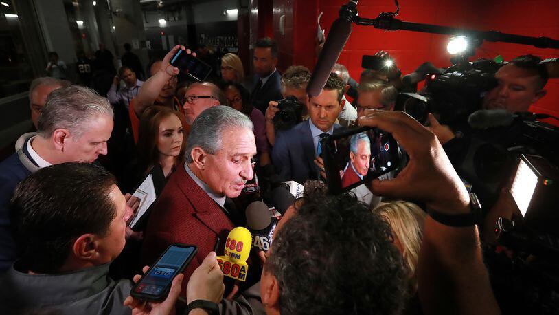 Falcons owner Arthur Blank is surrounded by media.