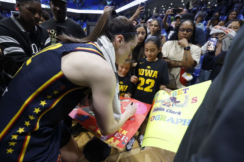 Indiana Fever guard Caitlyn Clark, left, signs autographs for Iowa fans after Indiana lost to the Dallas Wings during an WNBA basketball game in Arlington, Texas, Friday, May 3, 2024. (AP Photo/Michael Ainsworth)