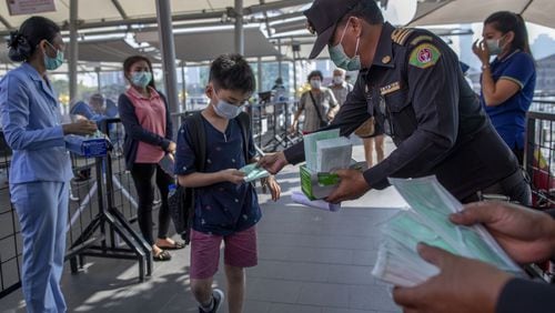 Health officials distribute protective face masks for visitors at a luxury mall in Bangkok, Thailand, Tuesday, Jan. 28, 2020. Panic and pollution drive the market for protective face masks, so business is booming in Asia, where fear of the new coronavirus from China is straining supplies and helping make mask-wearing the new normal.