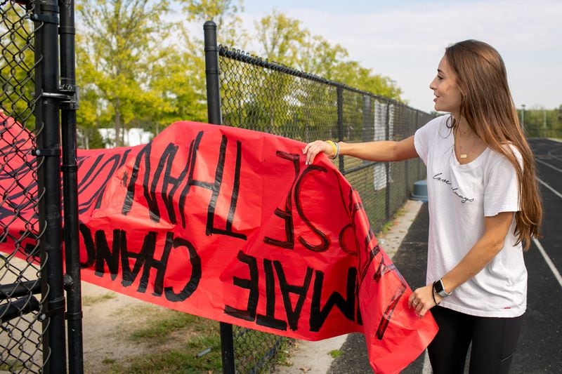 Danielle Milburn, senior at North Atlanta High School and climate walkout co-organizer, helps put up a banner before the school-wide climate walkout on Thursday, Sept. 26, 2019. REBECCA WRIGHT FOR THE ATLANTA JOURNAL CONSTITUTION