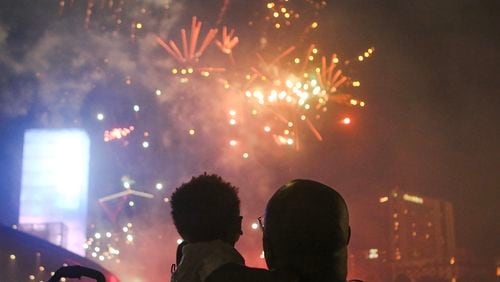 A man holds a child while they watch fireworks at Centennial Olympic Park in Atlanta on Thursday, July 4, 2019. The fireworks show, part of the annual Fourth of July celebration, was sponsored by the Georgia World Congress Center Authority and Coca-Cola. Christina Matacotta/Christina.Matacotta@ajc.com