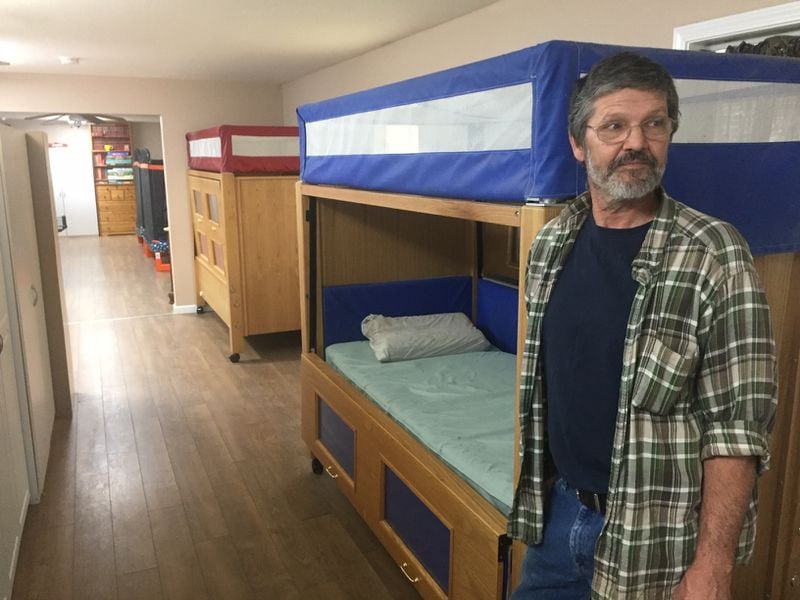 In the final years of The King's Cleft's operation, physically disabled children slept in these wooden beds that close and lock from the outside. David Fahey, seen here, said they kept children who couldn't walk from rolling onto the floor while sleeping. (Johnny Edwards / Johnny.Edwards@ajc.com)