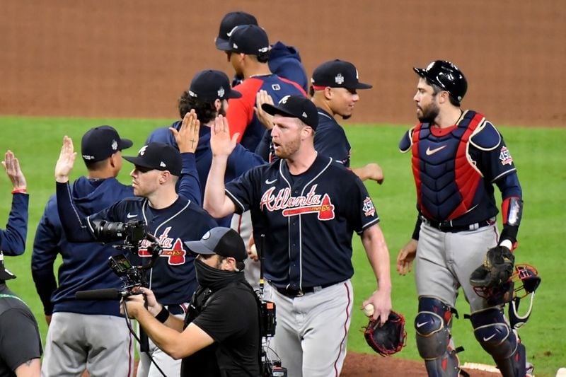 Braves relief pitcher Will Smith (center), catcher Travis d'Arnaud (right), and teammates celebrate their 6-2 win against the Houston Astros in Game 1 of the World Series Tuesday, Oct. 26, 2021, at Minute Maid Park, in Houston. (Hyosub Shin / Hyosub.Shin@ajc.com)