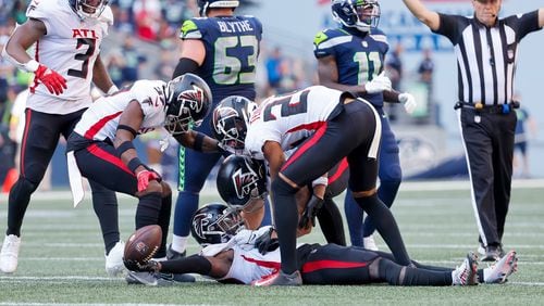 Teammates celebrate with Falcons safety Richie Grant after Grant intercepted a pass on fourth down to effectively end the game during the fourth quarter against the Seahawks on Sunday at Lumen Field in Seattle. (Jennifer Buchanan/The Seattle Times/TNS)