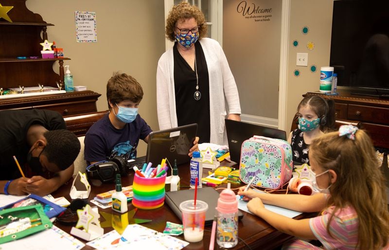  Cindy Nelson visits with the children while they work on their school assignments at the Nelson Elder Care Law office in Marietta. STEVE SCHAEFER FOR THE ATLANTA JOURNAL-CONSTITUTION