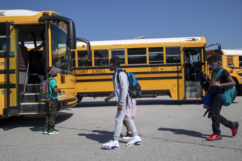 Clarkdale Elementary School students board their school bus at the end the school day in Austell, Monday, October 5, 2020. COVID-19 precautions for students are expected to continue into next school year. (Alyssa Pointer / Alyssa.Pointer@ajc.com)