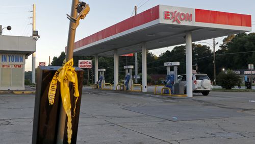 Crime scene tape is left on a pole outside an Exxon gas station off Glenwood Road, where a shooting Tuesday night left two dead and two injured.