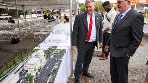 Brookhaven Mayor John Ernst, center, and Bill De St. Aubin, of the Sizemoregroup, looks at a model of the Brookhaven City Hall during the groundbreaking ceremony for Brookhaven’s $78 million City Hall at the Brookhaven MARTA Station parking lot, Wednesday, October 11, 2023, in Atlanta. (Jason Getz / Jason.Getz@ajc.com)