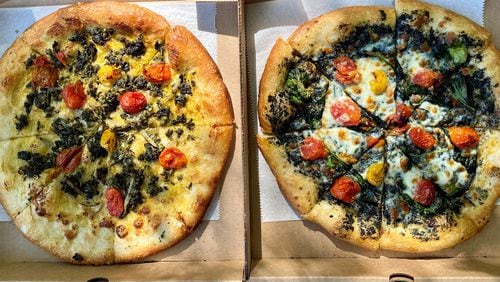 Dolos Pizza makes the Caribbean-inspired Vital pizza (left) with callaloo, roasted tomatoes and ackee sauce; and the Black pizza, with charcoal pesto, baby spinach, roasted tomatoes and mozzarella. Wendell Brock for The AJC