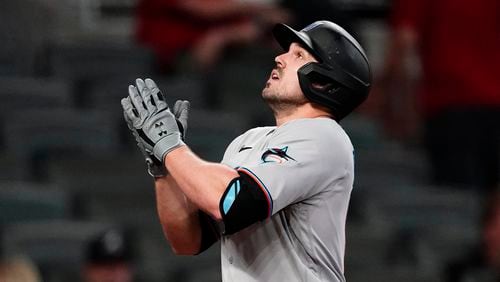 Miami Marlins' Adam Duvall gestures as he crosses the plate after hitting a three-run home run during the seventh inning of the team's baseball game against the Atlanta Braves on Tuesday, April 13, 2021, in Atlanta. (AP Photo/John Bazemore)