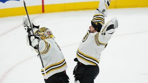 Boston Bruins goaltender Jeremy Swayman, left, and goaltender Linus Ullmark, right, celebrate after defeating the Toronto Maple Leafs in Game 4 of an NHL hockey Stanley Cup first-round playoff series in Toronto, Saturday, April 27, 2024. (Nathan Denette/The Canadian Press via AP)