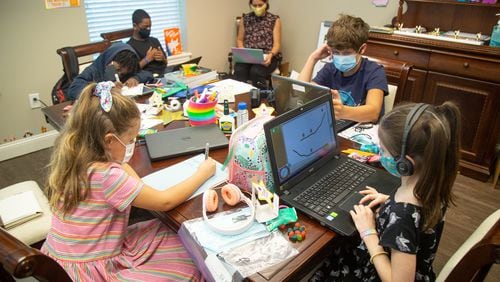 Elder Care Law office employee's children work on their schoolwork while being supervised by recent UGA graduate Sophia Ramirez in Marietta Monday, August 17, 2020. STEVE SCHAEFER FOR THE ATLANTA JOURNAL-CONSTITUTION