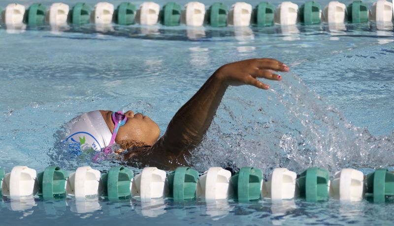 Sanaya McClendon, 8, competes in the backstroke in a swim meet at Leslie Beach Club in Atlanta on Saturday, May 21, 2022.    According to the USA Swimming Foundation, while most Americans learn how to swim during childhood, 64% of Black children in America have little to no swimming ability. (Bob Andres / robert.andres@ajc.com)