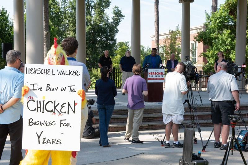 A Democratic operative dressed as a chicken mocked Herschel Walker outside of a campaign event in Alpharetta in July because the Republican had not committed to a debate against U.S. Sen. Raphael Warnock.
