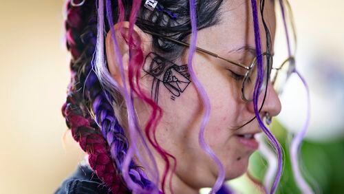 Kimra Luna, sporting a new face tattoo of a mailbox with abortive pills, packs abortion aftercare kits which will be mailed to Nebraska, S. Dakota and Idaho at their home in Nampa, Idaho, on Friday, April 12, 2024. “I wouldn’t be able to live with myself if I just acted scared and didn’t do the things that I do,” said the single parent of three boys. “I know I’m put here to do this.” (AP Photo/Kyle Green)