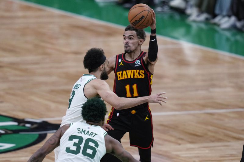 Atlanta Hawks guard Trae Young (11) passes the ball while pressured by Boston Celtics guard Derrick White during the second half of Game 2 in the first round of the NBA basketball playoffs, Tuesday, April 18, 2023, in Boston. (AP Photo/Charles Krupa)