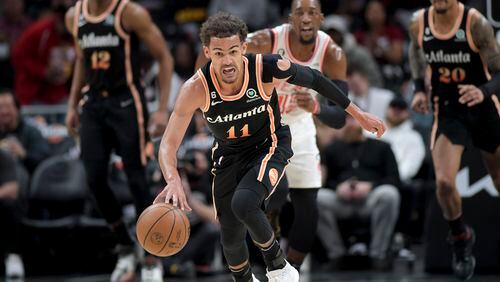 Hawks guard Trae Young breaks away during the first half Monday against the Heat at State Farm Arena. The Hawks haven’t folded despite myriad problems this season. They’ve created some harmony amid the noise by winning. (Daniel Varnado / for The Atlanta Journal-Constitution)