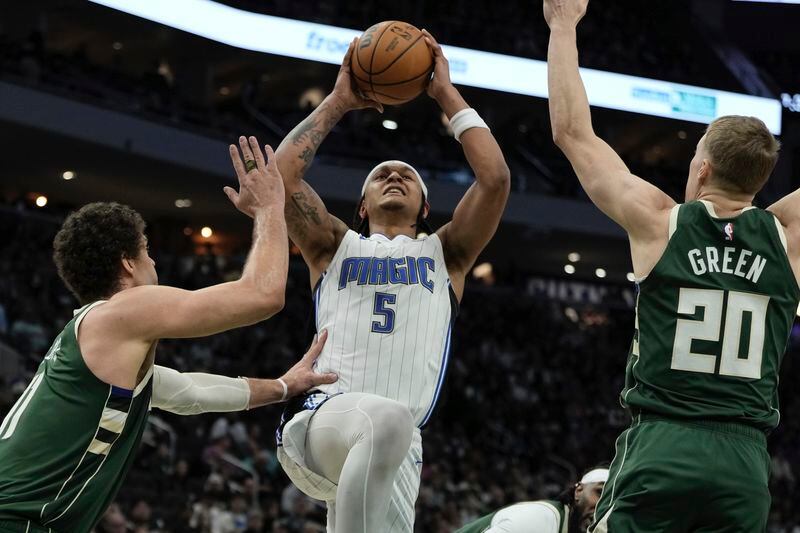 Orlando Magic's Paolo Banchero is foiled shooting between Milwaukee Bucks' Brook Lopez and AJ Green during the first half of an NBA basketball game Wednesday, April 10, 2024, in Milwaukee. (AP Photo/Morry Gash)