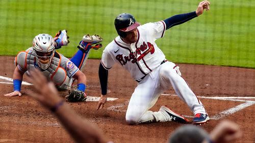 Atlanta Braves' Freddie Freeman (5) beats the tag from New York Mets catcher James McCann (33) to score on an Ozzie Albies base hit in the first inning of a baseball game Wednesday, June 30, 2021, in Atlanta. (John Bazemore/AP)