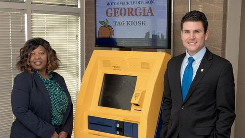 North Gwinnett tag office manager Elaine Melvin-Morgan, left, and Gwinnett Tax Commissioner Richard Steele pose with a new self-service kiosk. (AJC File Photo)