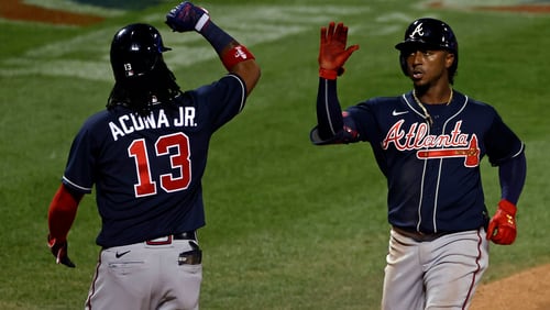 Atlanta Braves' Ozzie Albies is congratulated by Ronald Acuna Jr. (13) after hitting a two-run home run against the New York Mets during the seventh inning of a baseball game Sunday, July 26, 2020, in New York. (AP Photo/Adam Hunger)