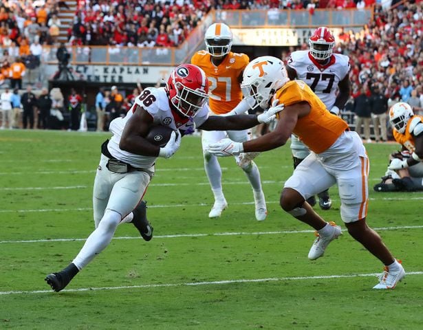 Georgia wide receiver Dillon Bell breaks away from Tennessee defender Gabe Jeudy-Lally for a touchdown to take a 17-7 lead during the second quarter in a NCAA college football game on Saturday, Nov. 18, 2023, in Knoxville.  Curtis Compton for the Atlanta Journal Constitution