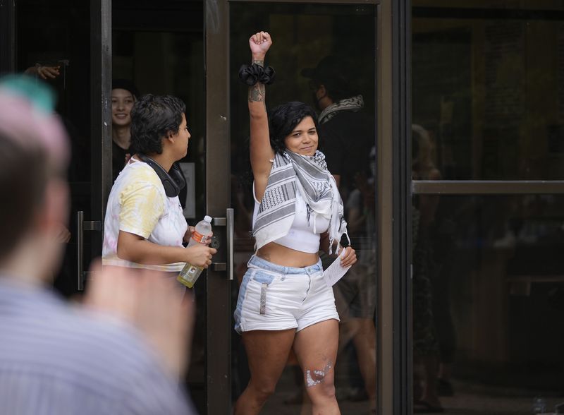 Pro-Palestinian protester Mercedes, a student at Southwestern University, raises a fist as she walks out of the Travis County Jail Tuesday April 30, 2024, a day after getting arrested at a protest at the University of Texas, in Austin, Texas. (Jay Janner/Austin American-Statesman via AP)