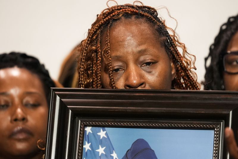 Chantimekki Fortson, mother of Roger Fortson, a U.S. Navy airman, holds a photo of her son during a news conference regarding his death, along with family and Attorney Ben Crump, Thursday, May 9, 2024, in Ft. Walton Beach, Fla. Fortson was shot and killed by police in his apartment on May 3, 2024. (AP Photo/Gerald Herbert)