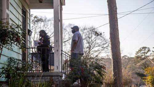 Atlanta police Sgt. A. Lavigeour (left) and Westview Community Organization President Jason Hudgins canvass houses in Atlanta’s Westview community Thursday as authorities continue searching for clues in the fatal shooting of 12-year-old David Mack.
