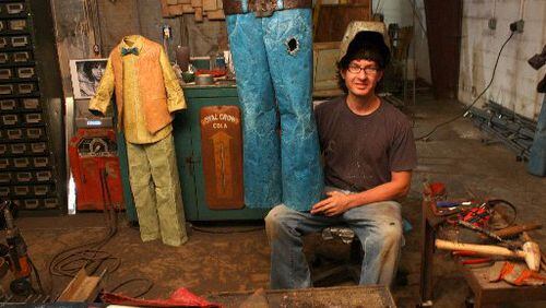 Dalton artist Chris Beck, holding up one of his sculptures in his studio, will show his works at Folk Fest this weekend.