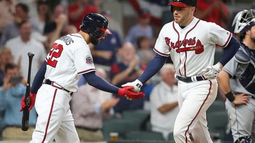 Braves first baseman Freddie Freeman gets five from Nick Markakis after hitting a two-run homer against the Padres on Monday. Curtis Compton/ccompton@ajc.com