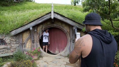 In this Thursday, Dec. 31, 2015 photo, tourists take photos during a tour of the Hobbit movie set near Matamata, New Zealand. In New Zealand there are twice as many cows as people, but it’s the hobbits that are really making hay. According to figures released Wednesday, Oct. 26, 2016, tourism has overtaken dairy as the nation’s top earner of overseas dollars. And tourism officials say the success of the fantasy movie trilogy “The Hobbit” has helped.(AP Photo/Mark Baker)