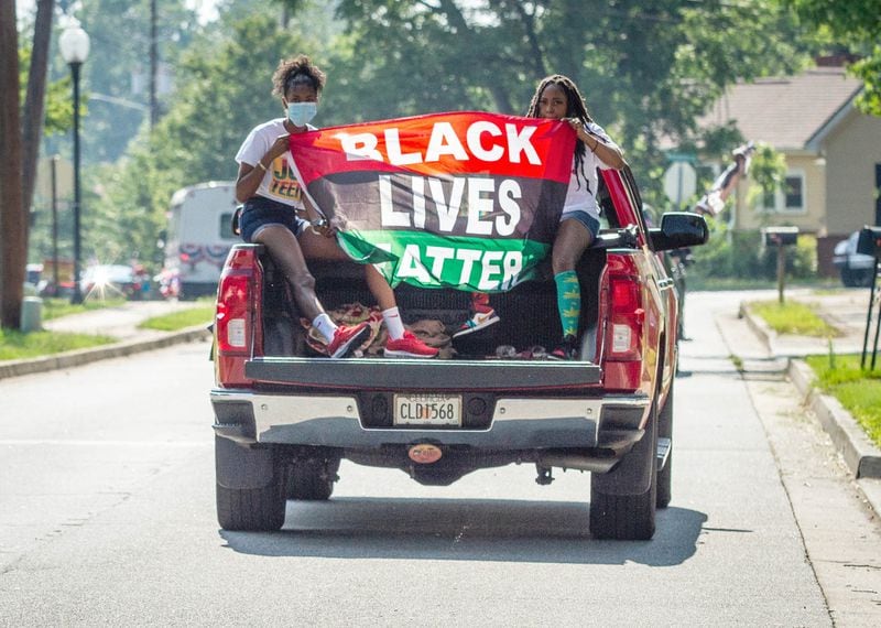 Cammy Gaines (L) and Stephanie Turner (R) hold a Black Lives Matter banner during the fourth of July Drive-By Parade in Powder Springs Saturday, July 4, 2020. The cars drove through different neighborhoods on their hour and a half parade through the community. STEVE SCHAEFER FOR THE ATLANTA JOURNAL-CONSTITUTION