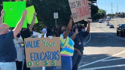 Protesters hold signs outside the DeKalb County School District's Stone Mountain headquarters on July 23, 2020. (Marlon A. Walker / MARLON.WALKER@AJC.COM)