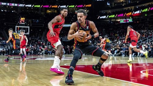 Trae Young secures a loose ball after a missed shot in Friday's Hawks-Raptors game at State Farm Arena.