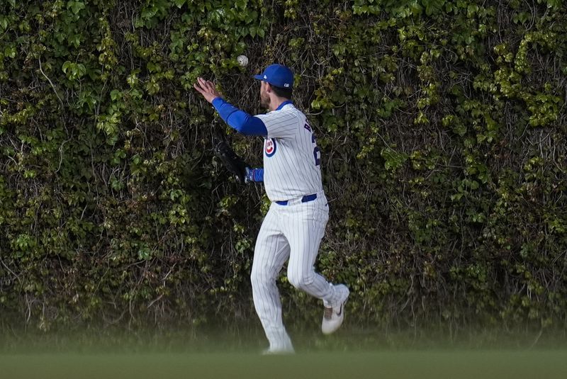 Chicago Cubs center fielder Cody Bellinger struggles to catch a fly ball from Houston Astros' Yainer Diaz as it bounces off the ivy during the fourth inning of a baseball game Tuesday, April 23, 2024, in Chicago. (AP Photo/Erin Hooley)
