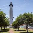 A crew works off scaffolding on the 145-foot Tybee Island lighthouse on May 23, 2024. The Historical Society is spending $1.8 million to replace the roof, the glass around the navigation light and the masonry on the 18th century landmark on Georgia's coast. (AJC Photo/Stephen B. Morton)