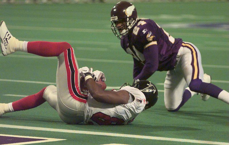 Terance Mathis rolls into the end zone ahead of Minnesota's Robert Griffith with 57 seconds remaining to force overtime in the 1998 NFC Championship game . (AJC File)
