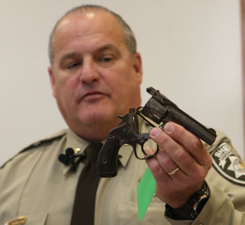 Woodstock Sheriff Roger Garrison in March 5, 2009, displaying a gun recovered from Woodstock High School after authorities received a tip. BOB ANDRES / bandres@ajc.com