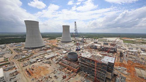 The cooling towers for Plant Vogtle Reactors 3 and 4 rise above the construction sites. AJC file