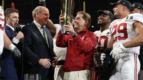 College Football Playoff executive director Bill Hancock awards a national championship trophy to Alabama coach Nick Saban. (File photo.)