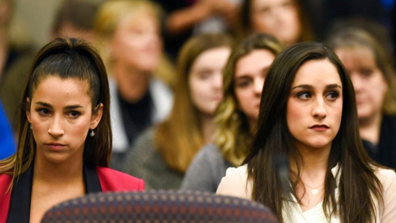 Former Olympians Aly Raisman, left, and Jordyn Wieber sit in Circuit Judge Rosemarie Aquilina's courtroom during the fourth day of sentencing for former sports doctor Larry Nassar, who pled guilty to multiple counts of sexual assault, Friday, Jan. 19, 2018, in Lansing, Mich. (Matthew Dae Smith /Lansing State Journal via AP)