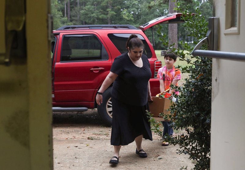Lisa Paul and her son John Daniel Paul carry supplies inside the Family Worship Center in Albany, Wednesday, October 10, 2018. Lisa’s husband, Pastor Bobby D. Paul Jr., is the leader at the Family Worship Center and chose to open the doors of the church to anyone seeking shelter during Hurricane Michael. (Alyssa Pointer/Alyssa.Pointer@ajc.com)